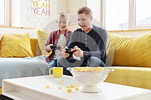 Happy young father and son boy 8 years old play together in a game console, fun and entertainment for the family