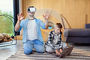 Happy young father and son testing virtual reality headset playing augmented video reality games.