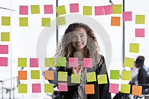 Happy young female business leader head shot through glass portrait