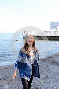 Happy young female develops hair and poses on camera, standing o