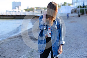 Happy young female develops hair and poses on camera, standing o