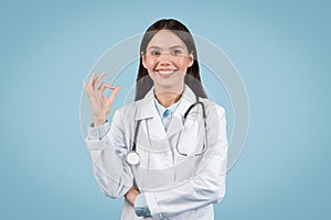 Happy young female doctor showing OK sign with hand