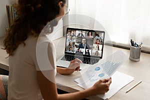 Happy young female employee holding video call meeting with colleagues.