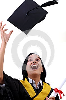 Happy young female graduate tossing up her hat