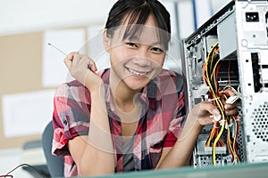 Happy young female pc technician in class