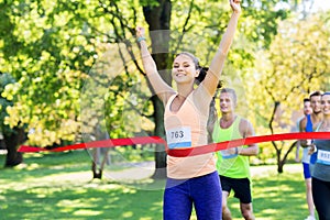 Happy young female runner on finish winning race