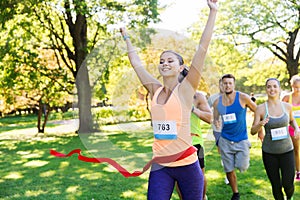 Happy young female runner winning on race finish