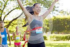 Happy young female runner winning on race finish