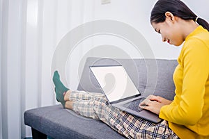 Happy young female surfing the internet shopping online at home after the government announced a ban on leaving the house.,