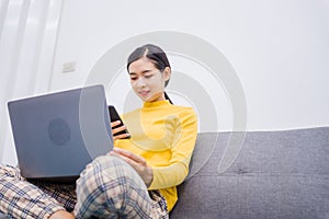 Happy young female surfing the internet shopping online at home after the government announced a ban on leaving the house.,