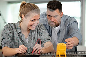 happy young female woker measuring electrical current