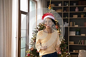 Happy young festive african american woman dancing to Christmas music.