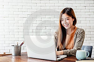 Happy Young Freelancer Woman Working on Computer Laptop in Cozy photo