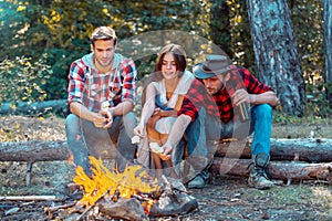 Happy young friends having picnic. Group of friends enjoying picnic in the forest. Happy friends on a camping trip