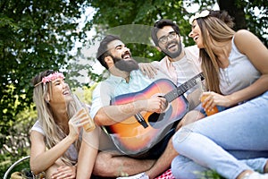 Happy young friends having picnic in the park