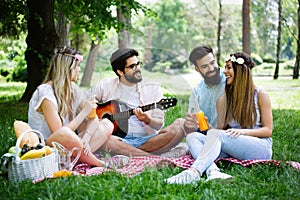 Happy young friends having picnic in the park