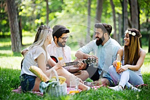 Happy young friends having picnic in the park