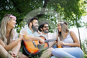 Happy young friends having picnic in the park