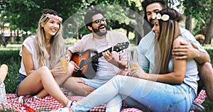 Happy young friends having picnic in the park