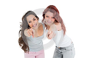 Happy young friends pointing against white background