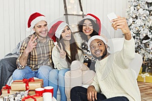 Happy young friends taking Cristmas selfie photo