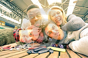 Happy young friends taking selfie indoors with back lighting