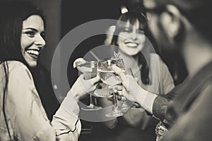 Happy young friends toasting and cheering cocktails at disco bar - Multiracial people having fun enjoying drinks at club