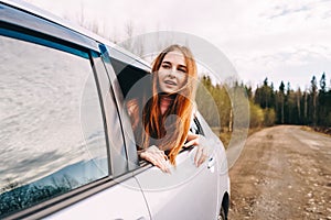 happy young ginger woman from window car