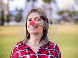 Happy young girl with a clown nose. Joke, humor and funny portrait concept. April fools day