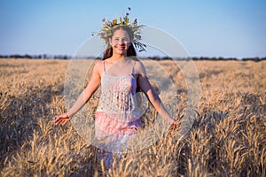 Young girl at field with ripe wheat