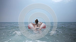 Happy young girl going to swim in blue sea.