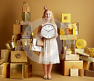 Happy young girl with gold shopping bags and round clocks