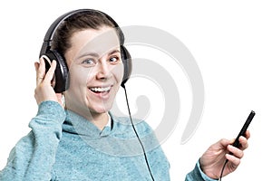 Happy young girl in headphones with player isolated on white background. A woman smiles and listens to music from the player. Mus