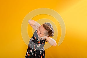 Happy young girl with her hands clasped together beneath her chin, smiling joyfully