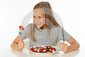 Happy young girl holding a plate full of candy lollies on white background