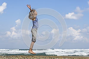 Happy young girl jumping on the beach
