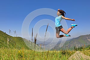 Happy young girl jumping and enjoying life in field