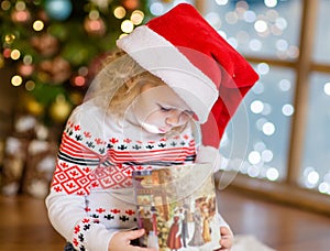 Happy young girl opening a gift box