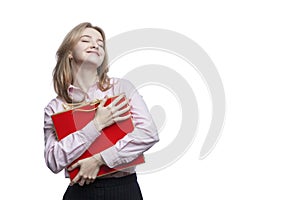 Happy young girl with a red gift bag in her hands. Cute smiling blonde girl wearing a pink shirt and blue trousers. Surprises and