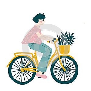 Happy young girl riding bicycle with front wicker basket and flowers, herbs in it. Cute funny smiling woman on bike. Adorable