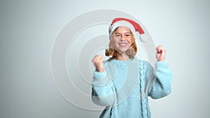 Happy Young girl in Santa Claus cap dancing