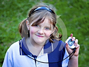 Happy young girl with stop watch at sports day