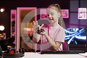 Happy young girl in studio reviewing gaming mouse in front of camera in personal studio