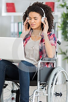 happy young girl in wheelchair on laptop at home