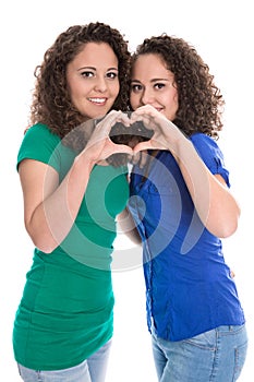 Happy young girls making heart with hands: real twin sisters.