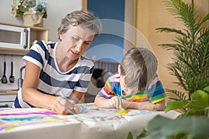 Happy young grandmother draw art picture playing grandson enjoy family weekend