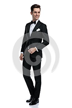 Happy young groom in tuxedo looking to side