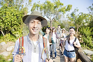 Happy young group hiking together through the forest