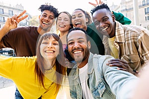 Happy young group of multiracial best friends having fun together outdoors