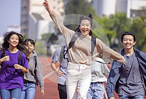 Happy young group students running Across Field